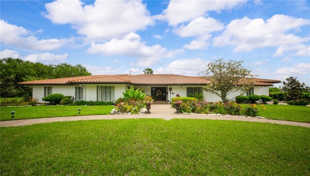 single story home with stucco siding, a tiled roof, and a front yard