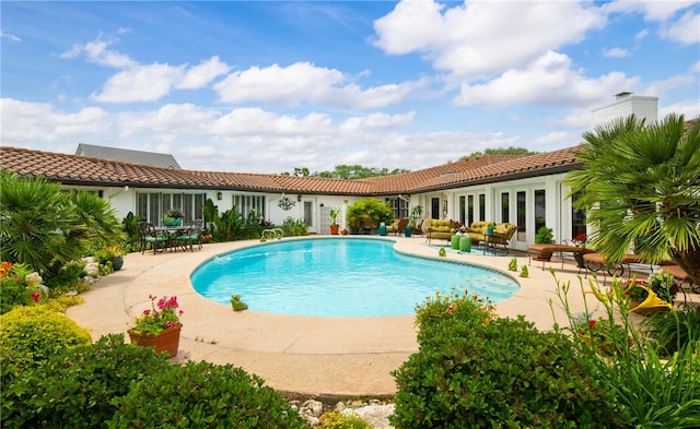 outdoor pool featuring french doors and a patio