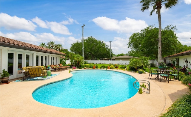 view of swimming pool featuring a fenced in pool, a patio area, fence, and french doors