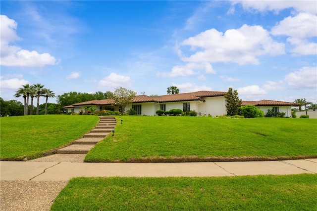 single story home with a tiled roof, a front lawn, and stucco siding