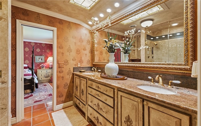 ensuite bathroom featuring crown molding, a sink, ensuite bathroom, and wallpapered walls
