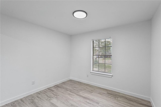 unfurnished room with baseboards and wood finished floors