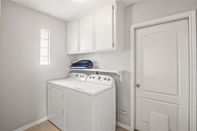 laundry area featuring cabinets, separate washer and dryer, and light hardwood / wood-style flooring