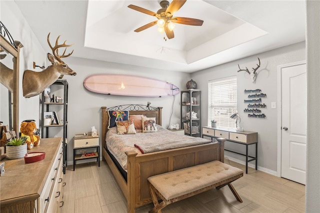 bedroom with ceiling fan and a raised ceiling