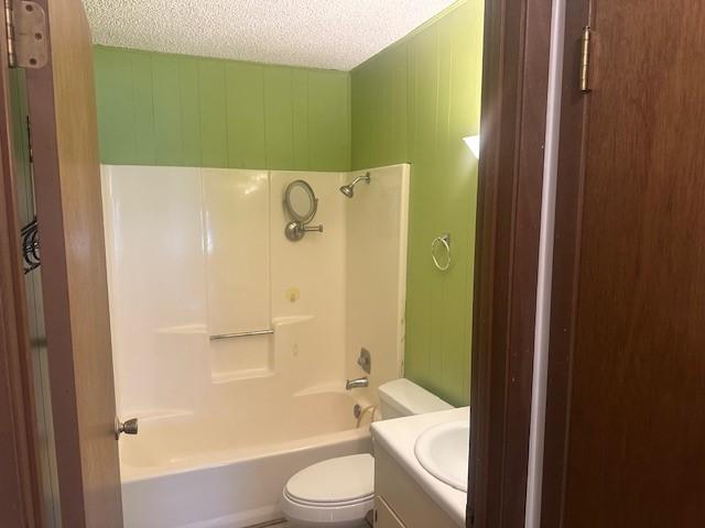 10949 Gates Ln, Corpus Christi, TX 78410 - bathroom featuring vanity, a textured ceiling, and bathing tub / shower combination