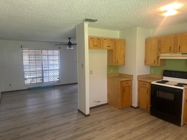 10949 Gates Ln, Corpus Christi, TX 78410 - kitchen featuring electric stove, under cabinet range hood, light wood finished floors, ceiling fan, and a textured ceiling