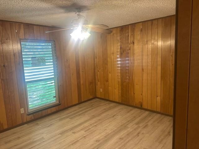 10949 Gates Ln, Corpus Christi, TX 78410 - unfurnished room with light wood-type flooring, a textured ceiling, ceiling fan, and wood walls