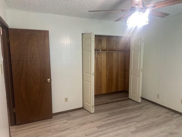 10949 Gates Ln, Corpus Christi, TX 78410 - unfurnished bedroom with a closet, light wood-style floors, a textured ceiling, and a ceiling fan