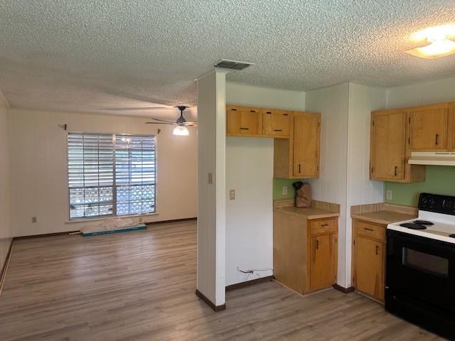 10949 Gates Ln, Corpus Christi, TX 78410 - kitchen with range with electric cooktop, under cabinet range hood, a textured ceiling, a ceiling fan, and light wood-style flooring