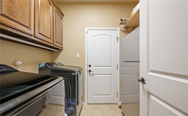 washroom featuring cabinets, separate washer and dryer, and light tile patterned floors