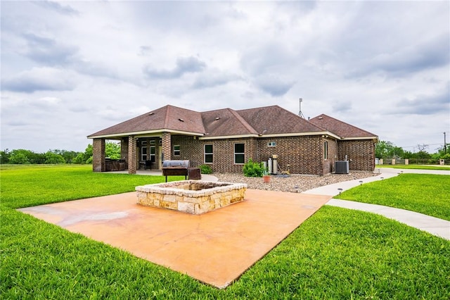 back of house with a lawn, a patio, central AC unit, and brick siding