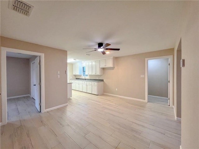 unfurnished living room featuring light wood-type flooring and ceiling fan