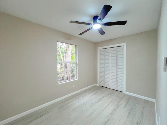 unfurnished bedroom featuring ceiling fan, a closet, and light hardwood / wood-style flooring