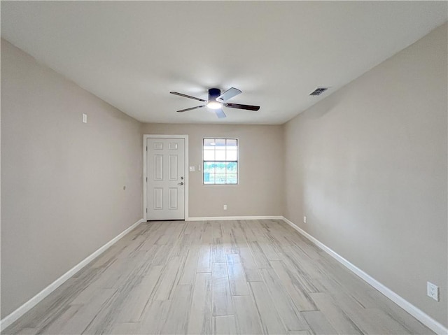 empty room with ceiling fan and light hardwood / wood-style flooring