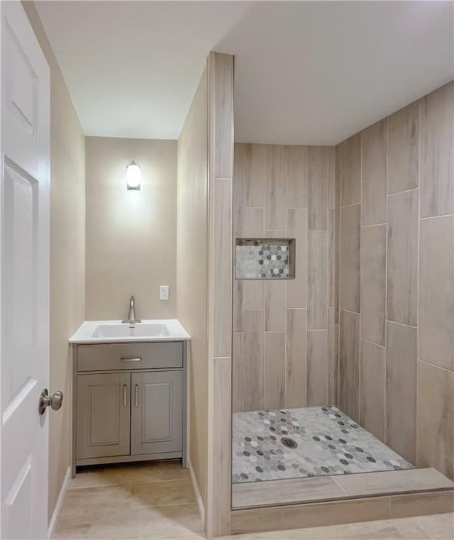 bathroom with vanity and tiled shower