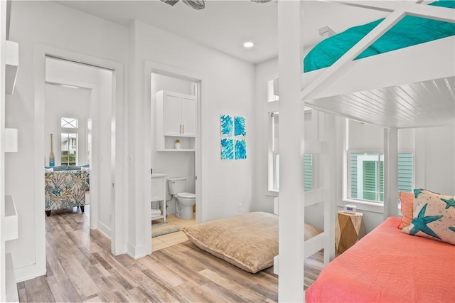 288 Hide Away Dr, Port Aransas, TX 78373 - bedroom with multiple windows, wood finished floors, connected bathroom, baseboards, and recessed lighting