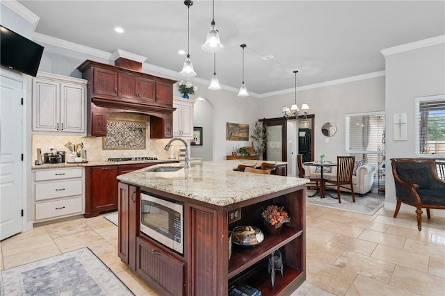 116 James Dr, Sinton, TX 78387 - kitchen with stainless steel appliances, a sink, tasteful backsplash, light stone countertops, and an island with sink