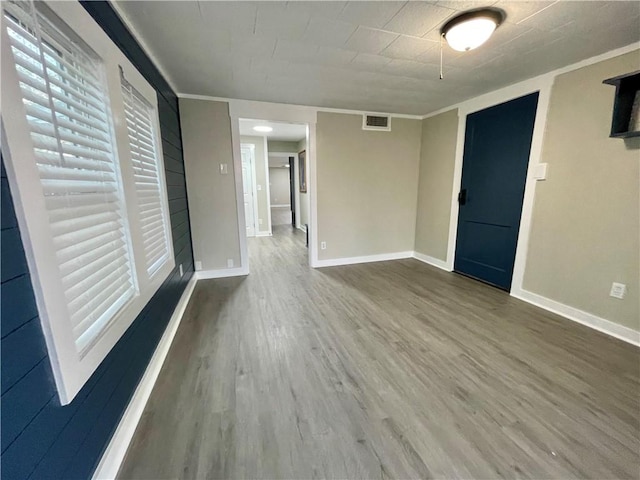 unfurnished room featuring wood-type flooring and ornamental molding