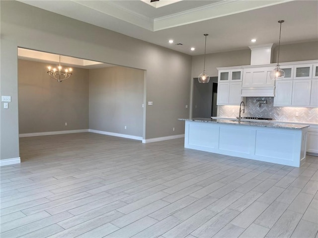 13941 Flintlock Dr, Corpus Christi, TX 78418 - kitchen with backsplash, recessed lighting, white cabinetry, a chandelier, and a kitchen island with sink