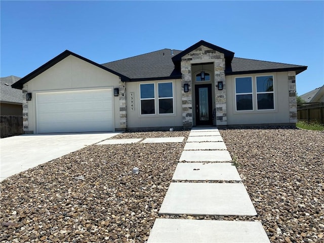 13941 Flintlock Dr, Corpus Christi, TX 78418 - single story home featuring a garage, concrete driveway, a shingled roof, and stone siding