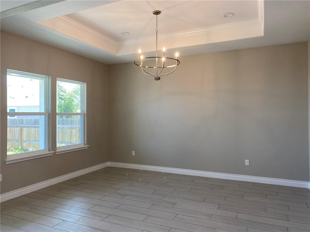 13941 Flintlock Dr, Corpus Christi, TX 78418 - empty room featuring a chandelier, a raised ceiling, crown molding, and light wood-type flooring