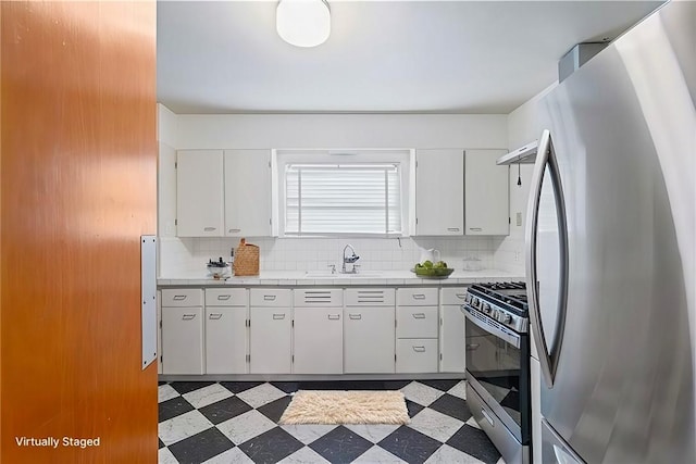 kitchen with stainless steel appliances, white cabinetry, tasteful backsplash, and sink