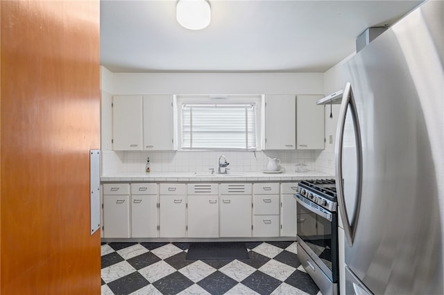 kitchen featuring white cabinets, backsplash, stainless steel appliances, and sink