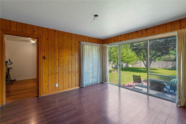 empty room featuring a notable chandelier and dark wood-type flooring