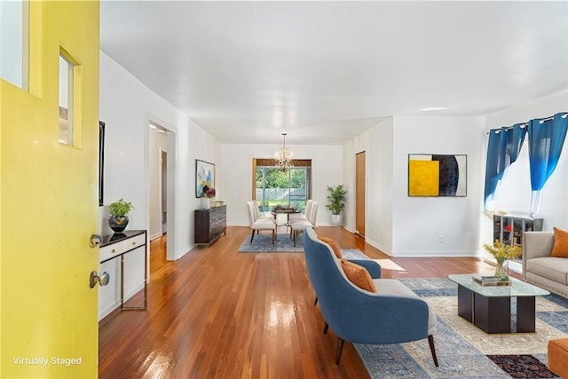 living room featuring hardwood / wood-style flooring and an inviting chandelier