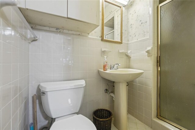 bathroom featuring tile walls and toilet