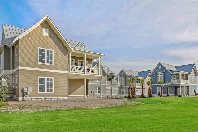 rear view of house featuring a lawn and a balcony