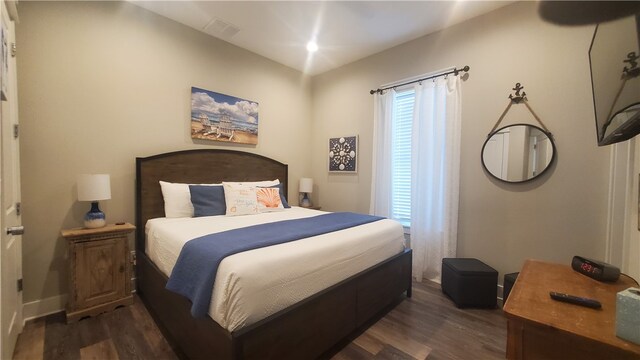 bedroom with dark hardwood / wood-style floors