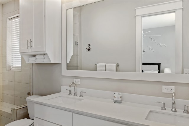 bathroom with toilet, vanity, and a shower with shower door