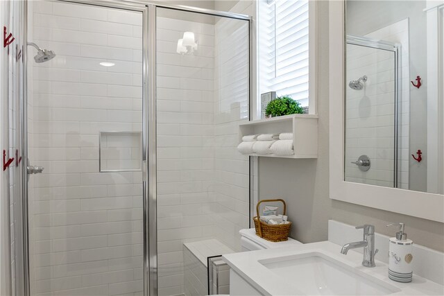 bathroom with toilet, vanity, and walk in shower