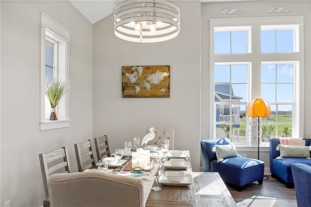 dining area with dark hardwood / wood-style floors, a chandelier, and vaulted ceiling