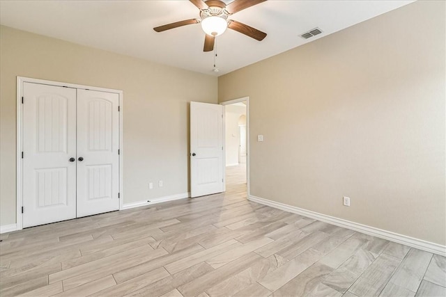 unfurnished bedroom with ceiling fan, a closet, and light wood-type flooring