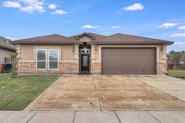 prairie-style house with a front yard, stone siding, a garage, stucco siding, and driveway