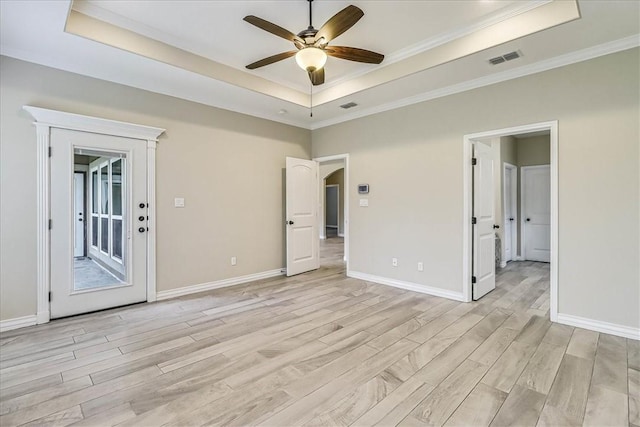 interior space featuring crown molding, a tray ceiling, light hardwood / wood-style floors, and ceiling fan