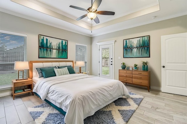 bedroom with ceiling fan, ornamental molding, access to exterior, and a raised ceiling