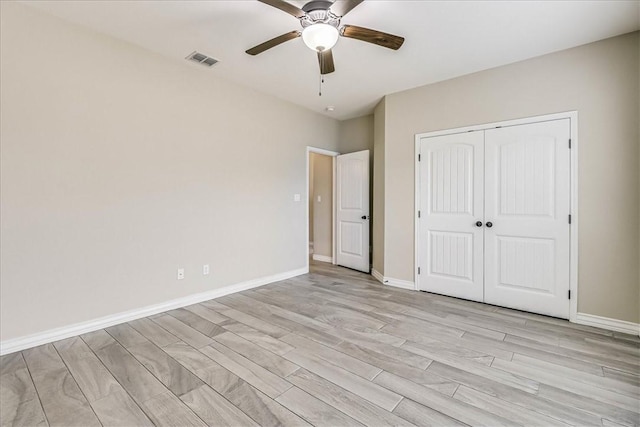 unfurnished bedroom with ceiling fan and a closet