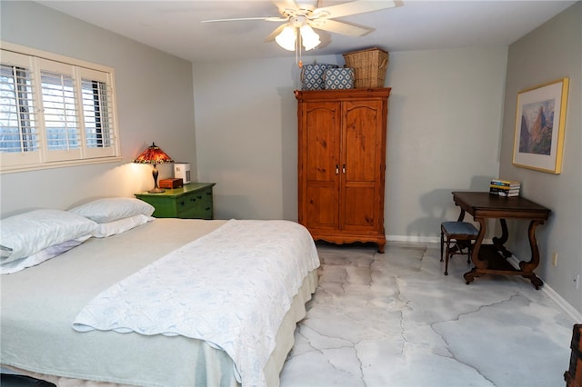 bedroom featuring concrete flooring, a ceiling fan, and baseboards