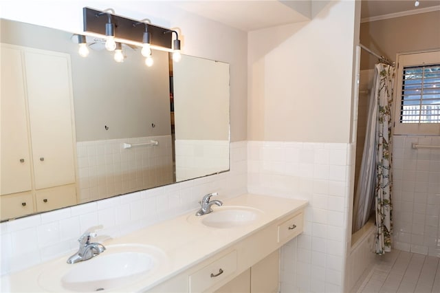 bathroom with double vanity, shower / bath combo, a sink, and tile walls