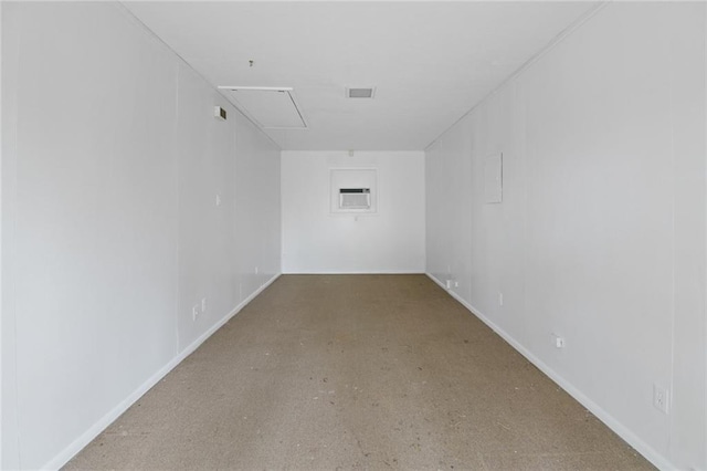 spare room with attic access, visible vents, and baseboards