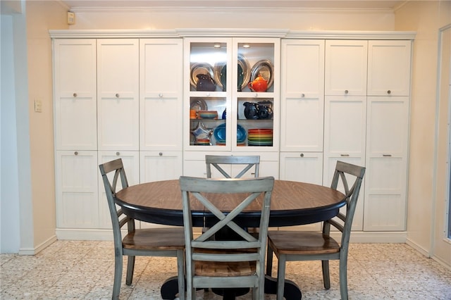 dining space with ornamental molding and baseboards