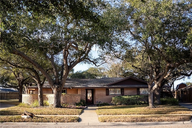 single story home with brick siding, a front lawn, and fence