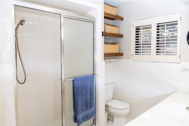 full bathroom with toilet, a wainscoted wall, a shower stall, and tile walls