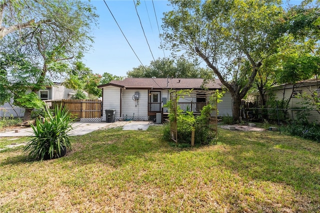 rear view of property with a patio area, a yard, and a deck