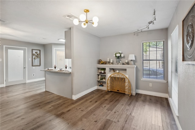 living room featuring hardwood / wood-style floors, a notable chandelier, and track lighting