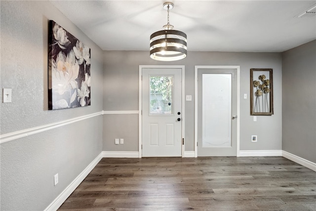 foyer featuring an inviting chandelier and dark hardwood / wood-style flooring