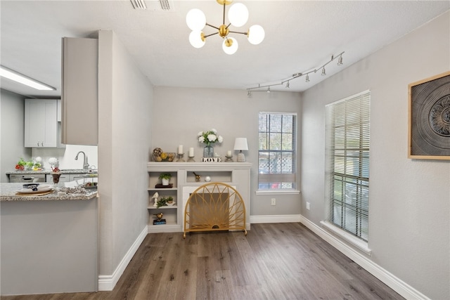 interior space featuring dark wood-type flooring, sink, and an inviting chandelier